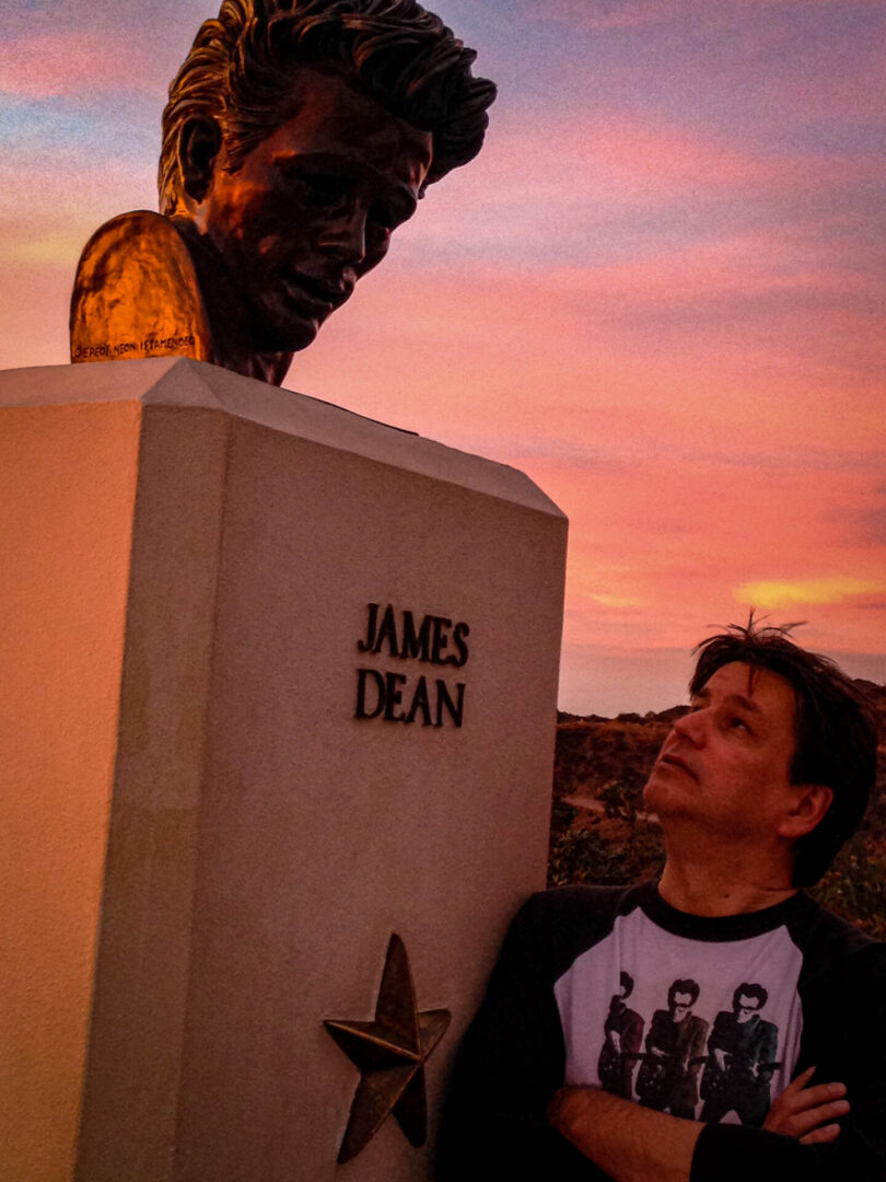 John Pepin looking up at a head bust of James Dean